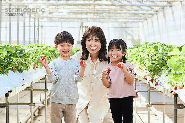 Asian woman and children in a greenhouse