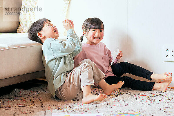 Happy Japanese kids playing on the floor