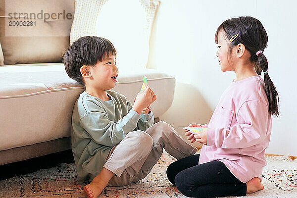 Happy Japanese kids playing on the floor