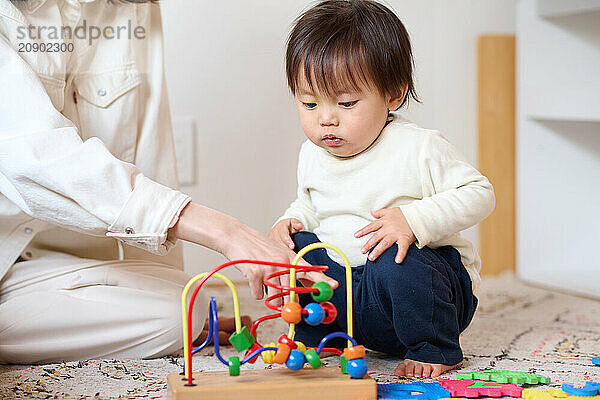 Asian woman and child playing with wooden toys