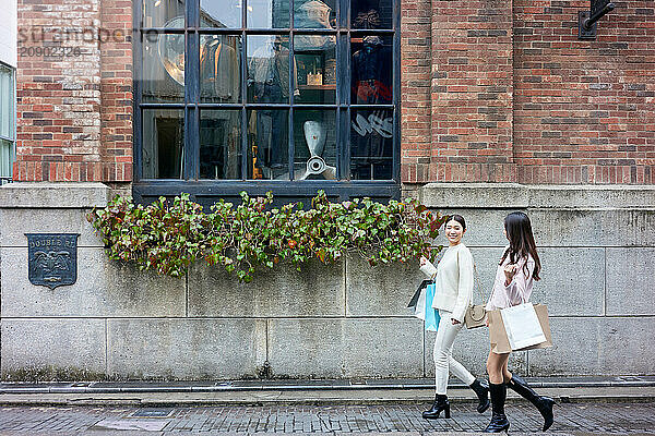 Two Women Walking Down The Street