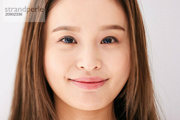 Asian Woman With Long Brown Hair And A Smile