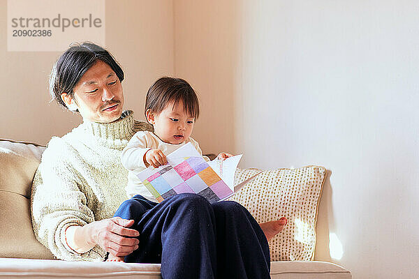 Japanese father and son reading a book