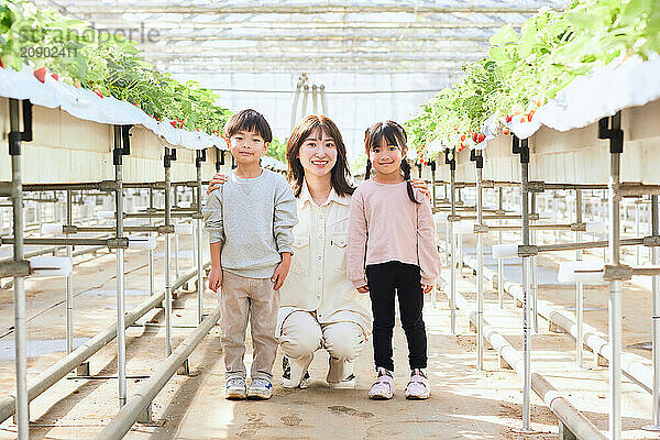 Asian woman and children in a greenhouse