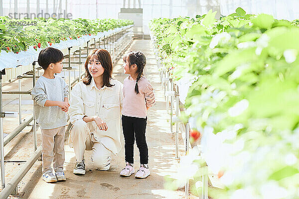 Asian woman and children in a greenhouse