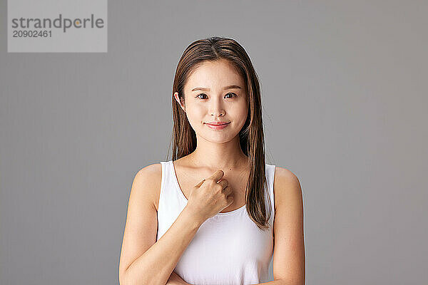 Asian Woman In White Tank Top Posing For The Camera