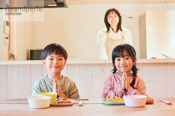 Happy Japanese kids eating in the dining room