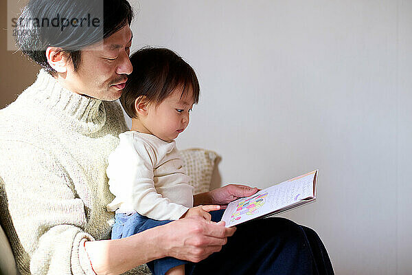 Japanese father and son reading a book