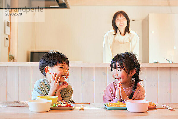 Happy Japanese kids eating in the dining room