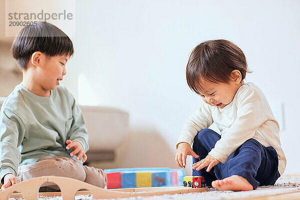 Happy Japanese kids playing on the floor