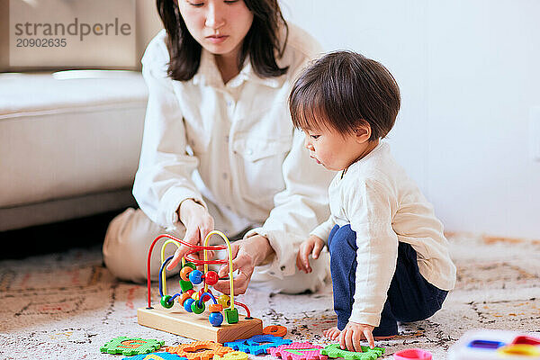 Asian child playing with wooden toys