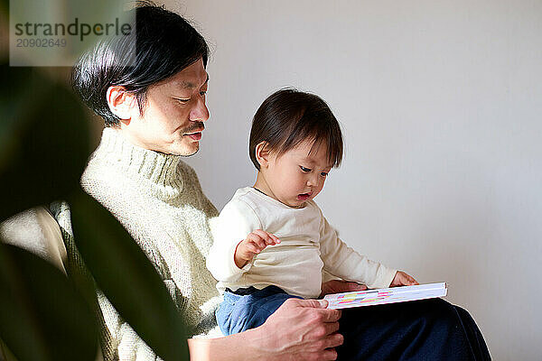 Japanese father and son reading a book