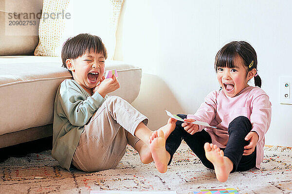 Happy Japanese kids playing on the floor