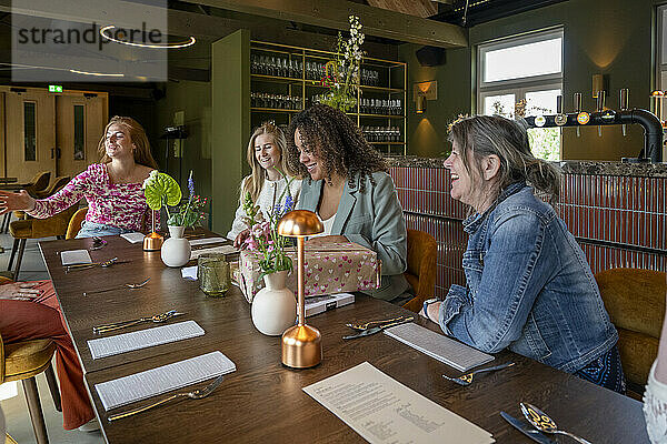 A group of women enjoying a moment together in a well-lit restaurant with modern decor.