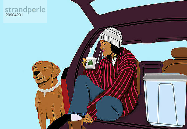 A woman in a striped jacket and beanie relaxes in an open trunk of a car with a brown dog beside her  holding a beverage.