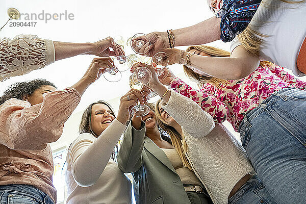 Group of friends toasting with champagne at a celebration  captured from a low angle.