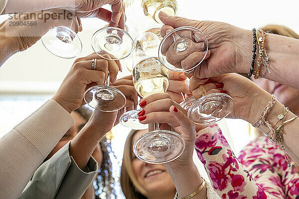 Hands toasting with champagne glasses at a celebratory event.