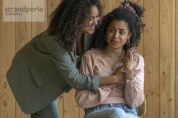 Two women share a comforting embrace  one offering support to the other who appears distressed.