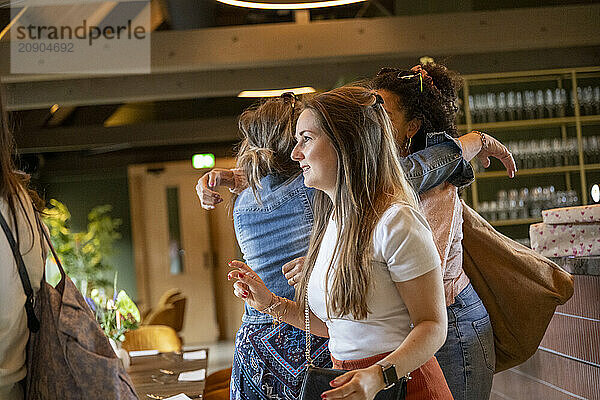 Group of women enjoying a casual get-together indoors  with smiles and engaged in relaxed conversation.