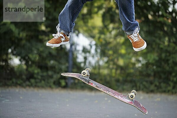 Eine Person macht einen Kickflip auf einem Skateboard in Berlin  16.08.2024