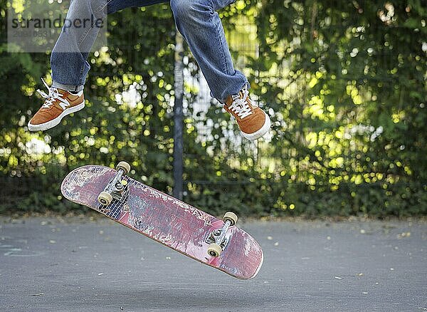 Eine Person macht einen Kickflip auf einem Skateboard in Berlin  16.08.2024