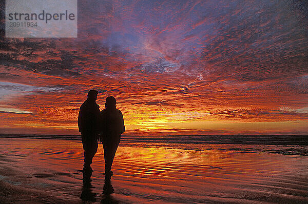 Zwei Freundinnen beobachten den unglaublichen Sonnenuntergang am Nye Beach  Newport  Küste von Oregon