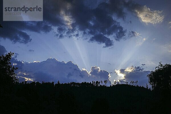 Symbolfoto. Die Sonne geht hinter einem mit Nadelbäumen bewachsenen Berg unter. Ziegenrück  20.07.2024