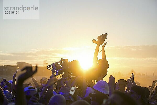 Ein Rollstuhlfahrer beim Crowdsurfen vor Sonnenuntergang beim Highfield Festival am Freitag  Störmthaler See  16.08.2024