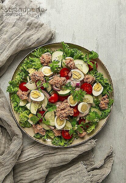 Thunfischsalat  Gemüsesalat mit Wachteleiern  Kopfsalat  roten Zwiebeln und Gurken  auf einem hellgrauen Tisch  Keto Food  Lifestyle  gesunde Ernährung  selektiver Fokus  Draufsicht  keine Menschen