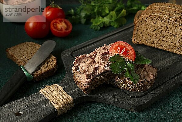 Leberpastete auf Roggenbrot  Frühstück  Nahaufnahme  dunkler Hintergrund  keine Personen  selektiver Fokus