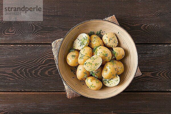 Frisch gekochte  neue Kartoffeln  mit Dill  auf einem Holztisch  selektiver Fokus. Nahaufnahme  Tonung  keine Personen