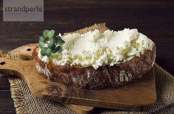 Sandwich  mit Frischkäse  hausgemacht  auf einem Schneidebrett  rustikal  ohne Menschen  selektiver Fokus  Frühstück