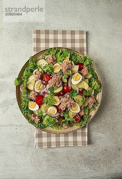 Thunfischsalat  Gemüsesalat mit Wachteleiern  Kopfsalat  roten Zwiebeln und Gurken  auf einem hellgrauen Tisch  Keto Food  Lifestyle  gesunde Ernährung  selektiver Fokus  Draufsicht  keine Menschen