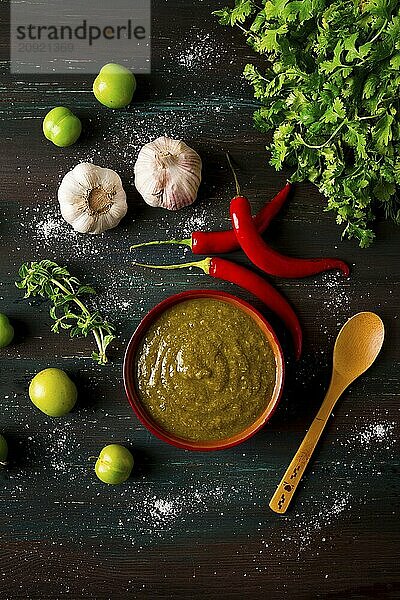 Tkemali Sauce  traditionelle georgische Küche  grüne Kirschpflaume  mit Zutaten für die Sauce  Koriander  Minze  scharfer Pfeffer  Knoblauch  auf einem Holztisch  Nahaufnahme  rustikal  Lebensmittel Hintergrund  keine Menschen  selektiver Fokus  Sauce  grüne Sauce  tkemali  georgische Küche  hausgemacht