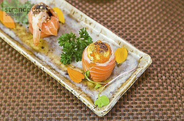 Teller mit verschiedenen Geschmacksrichtungen von eleganten Sushi dekoriert. Selektiver Fokus