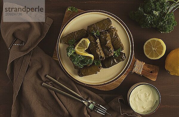 Dolma  Kohlrouladen  Traubenblätter mit Füllung  weiße Soße  Zitrone und Kräuter  rustikal  selektiver Fokus  keine Menschen