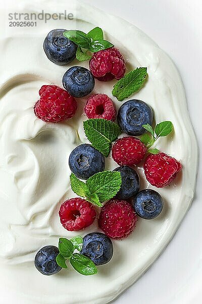 Frühstück  Joghurt mit frischen Beeren  Himbeeren und Heidelbeeren  auf einem weißen Hintergrund  selektiver Fokus  keine Menschen  gesunde Lebensmittel