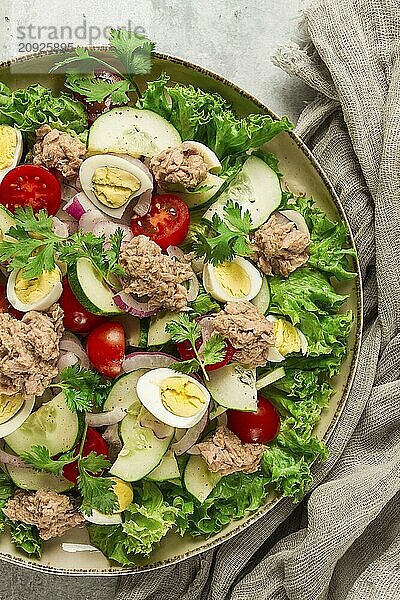 Thunfischsalat  Gemüsesalat mit Wachteleiern  Kopfsalat  roten Zwiebeln und Gurken  auf einem hellgrauen Tisch  Keto Food  Lifestyle  gesunde Ernährung  selektiver Fokus  Draufsicht  keine Menschen