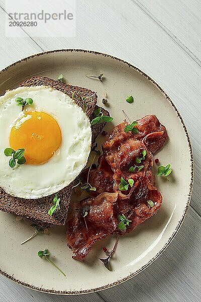 Frühstück  Spiegelei mit Speck  mikro grün  auf einem hellen Hintergrund  keine Menschen  selektiver Fokus