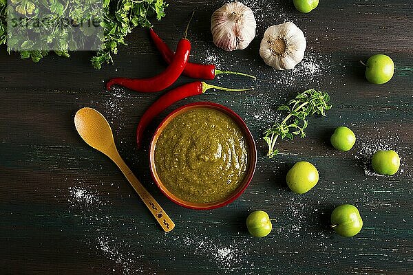 Tkemali Sauce  traditionelle georgische Küche  grüne Kirschpflaume  mit Zutaten für die Sauce  Koriander  Minze  scharfer Pfeffer  Knoblauch  auf einem Holztisch  Nahaufnahme  rustikal  Lebensmittel Hintergrund  keine Menschen  selektiver Fokus  Sauce  grüne Sauce  tkemali  georgische Küche  hausgemacht