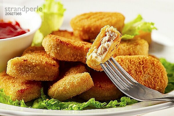 Gebratene Hähnchenbrust Nuggets  auf Salatblättern  mit Tomatensauce  horizontal  ohne Personen  selektiver Fokus