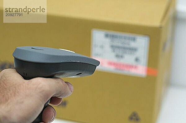 Großes Konzept der Rückverfolgbarkeit  ERP System  Hand kriechen Produkt Barcode und Verpackung. Der Mann bekommt auf der Hüfte Scanner in Operationen auf gedruckten Barcode gerichtet. Lagerhaus Szene. Flache Tiefenschärfe!