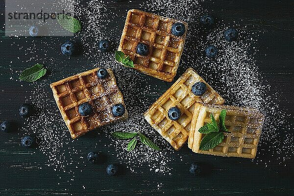 Wiener Waffeln mit Blaubeeren  vor dunklem Hintergrund  Frühstück  keine Menschen  selektiver Fokus