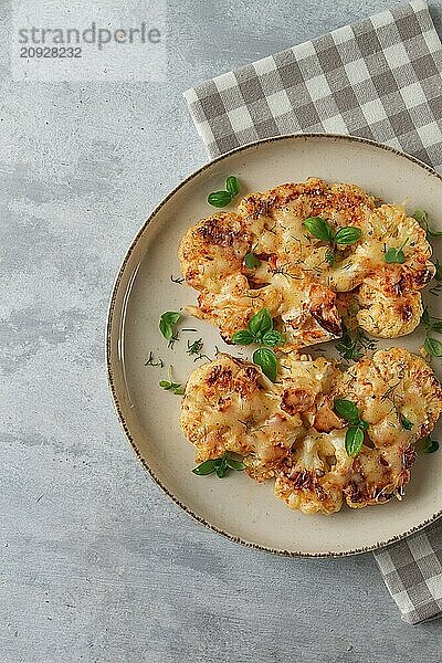 Steak  Blumenkohl  mit Käse  Gewürzen  hausgemacht  auf einem hellgrauen Tisch  Nahaufnahme  Draufsicht  selektiver Fokus  keine Personen