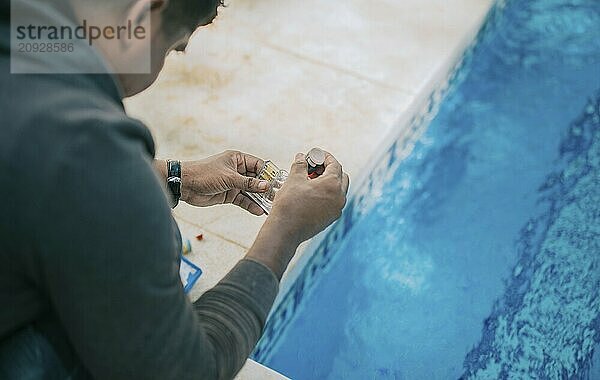 Testkit zur Messung von Chlor und pH Wert in Schwimmbädern. Person  die den PH Wert des Pools testet