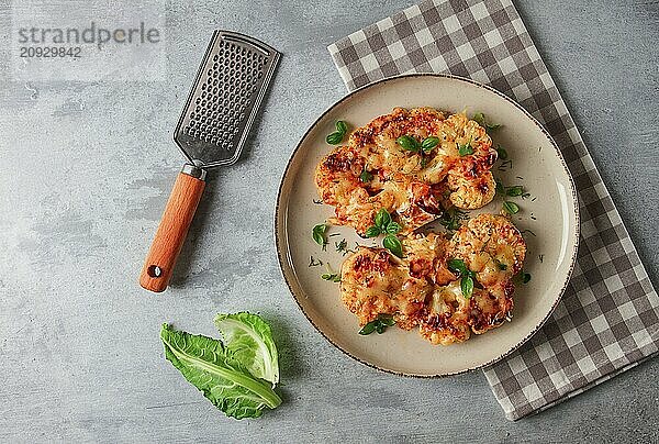 Steak  Blumenkohl  mit Käse  Gewürzen  hausgemacht  auf einem hellgrauen Tisch  Nahaufnahme  Draufsicht  selektiver Fokus  keine Personen