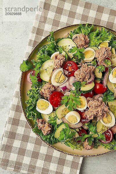 Thunfischsalat  Gemüsesalat mit Wachteleiern  Kopfsalat  roten Zwiebeln und Gurken  auf einem hellgrauen Tisch  Keto Food  Lifestyle  gesunde Ernährung  selektiver Fokus  Draufsicht  keine Menschen