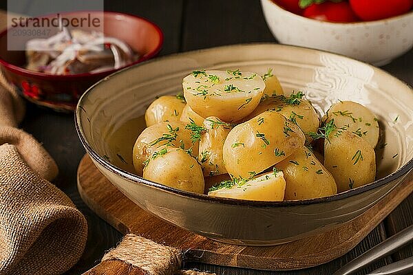 Frisch gekochte  neue Kartoffeln  mit Dill  auf einem Holztisch  selektiver Fokus. Nahaufnahme  Tonung  keine Personen