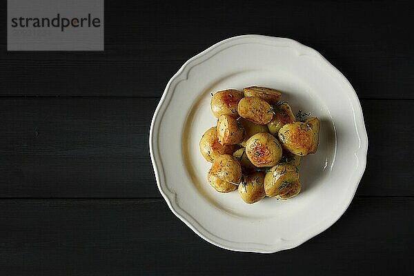 Frisch gekochte  neue Kartoffeln  mit Dill  auf einem Holztisch  selektiver Fokus. Nahaufnahme  Tonung  keine Personen