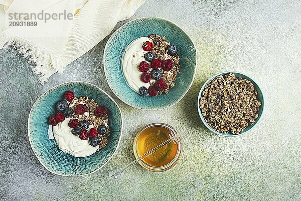 Frühstück  zwei Schalen  Joghurt  Müsli mit Beeren und Honig  selbst gemacht  keine Leute